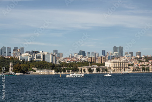View of boats on Bosphorus  historical Dolmabahce Palace and European side of Istanbul. It is a sunny summer day.