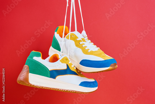 Flying trendy sneakers on creative colorful background, Stylish fashionable minimalism concept, Levitation shoes photo