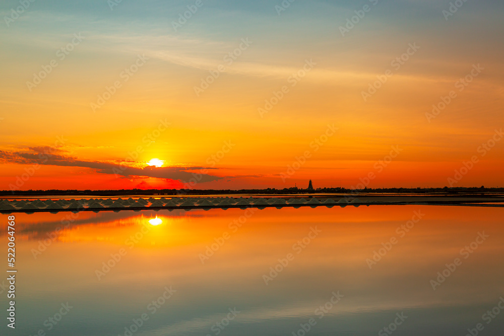 Fototapeta premium Salt farm in Thailand,Salt industry,sunset on a pink salt lake,Sunset salt farming Naklua in the coastal, Phetchaburi provinces of Thailand, Landscape, a former mine for the extraction of pink salt