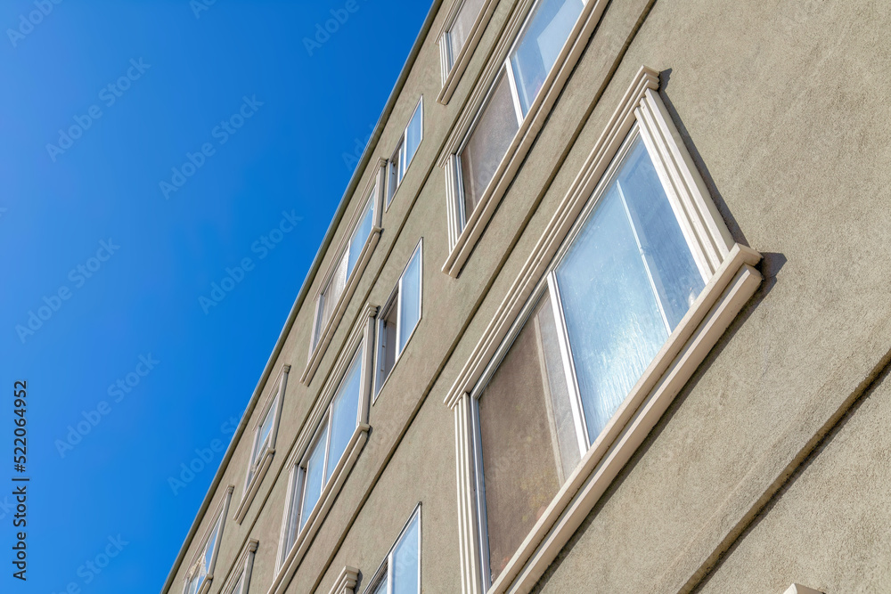 Gray stucco wall and sliding window with screen of an apartment building in San Francisco, CA