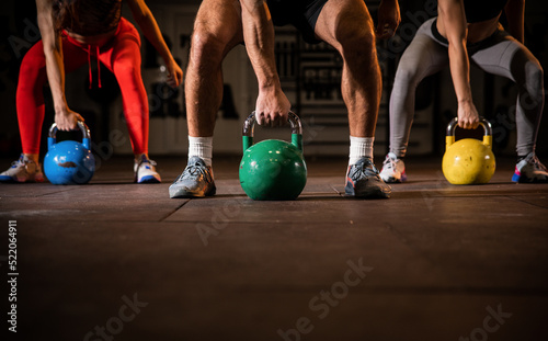 Group having functional fitness training with kettlebell in sport gym