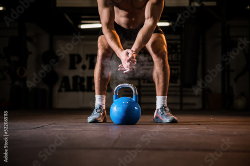 Weightlifter clapping hands and preparing for workout at a gym.