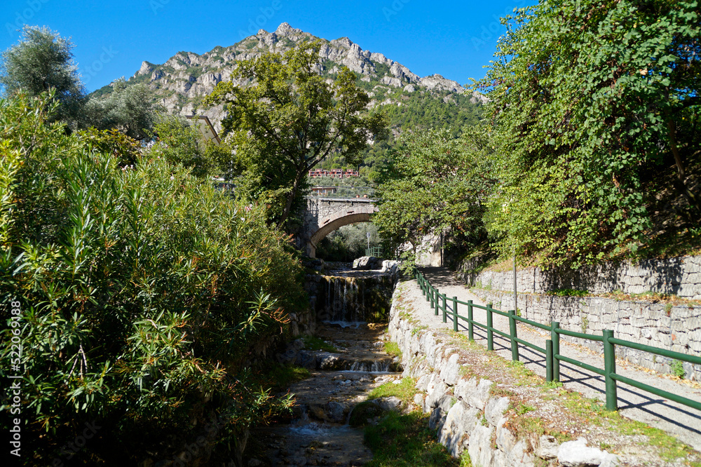 an old stone bridge over the San Giovanni stream (Torrente San Giovanni) in gorgeous green Italian town of Limone sul Garda on lake Garda (Italy, Lombardy)	
