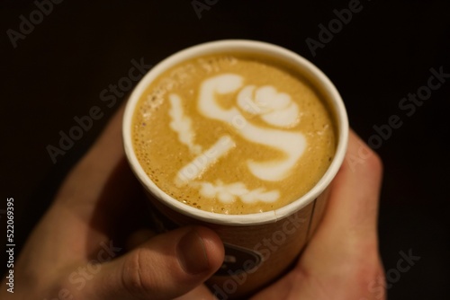 A person holding an artistic and velvety latte