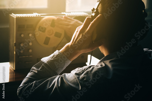 Secret agent listens on the reel tape recorder. Officer wiretapping in headphones. Spying of conversations. Intelligence gathering. Espionage concept. Report information to superiors.