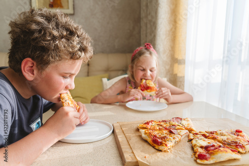 Children eating homemade pizza at home. photo