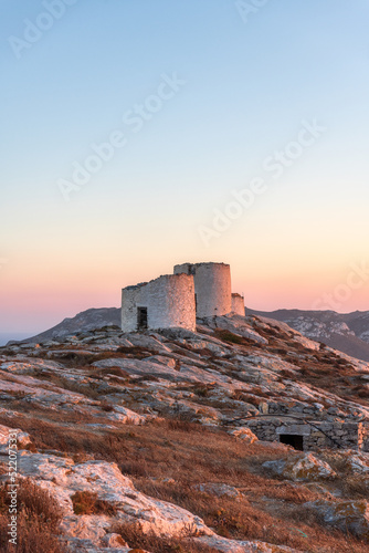 Traditional windmills of Chora, on Amorgos island in Greece during sunset.