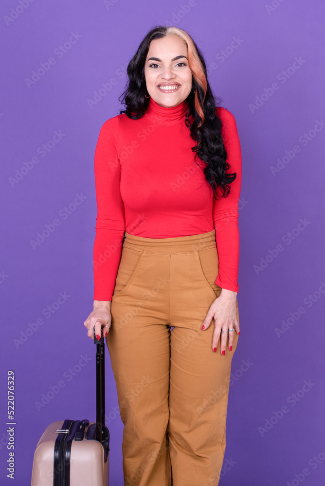 Young woman traveler with suitcase against purple background. Young woman traveler with suitcase against purple background.