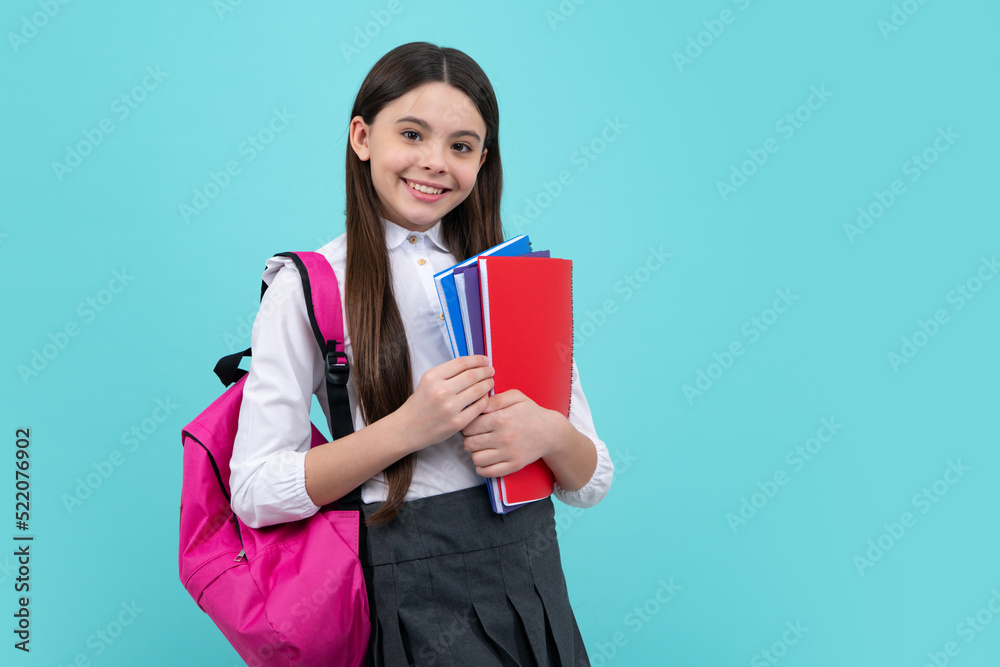 Schoolchild, teenage student girl with school bag backpack hold book on blue isolated studio background. Children school and education concept. Schoolchild, teenage student girl with school bag backpack hold book on blue isolated studio background. Children school and education concept.