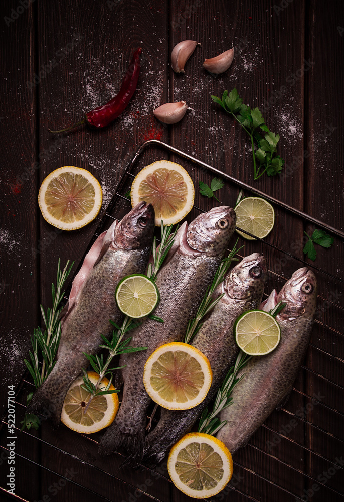 Raw rainbow trout, with lemon and herbs, on a wooden table, no people,