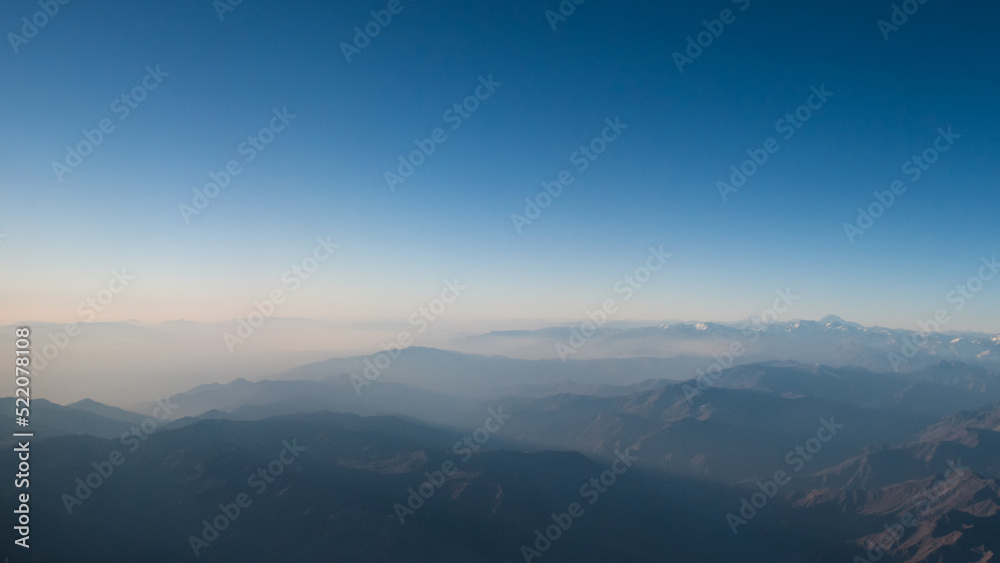 Vista de la Cordillera de los Andes con bruma, al atardecer de otoño, toma hecha desde un avion