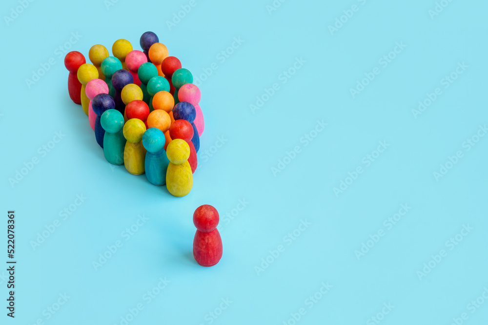 Inclusive Leadership concept. A group of multi-colored figurines and one in front. Inclusive Leadership concept. A group of multi-colored figurines and one in front.