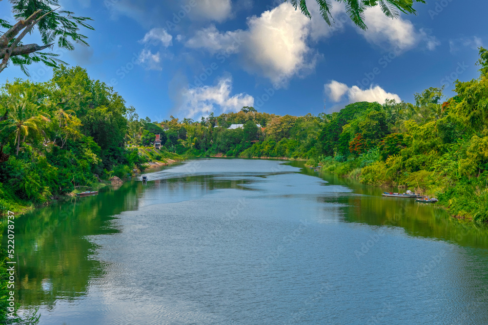 Luang Prabang Laos, beautiful river surrounded by lush green mountains and lovely historical houses