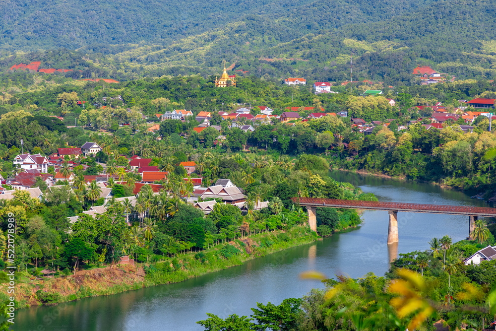 Luang Prabang Laos, beautiful river surrounded by lush green mountains and lovely historical houses