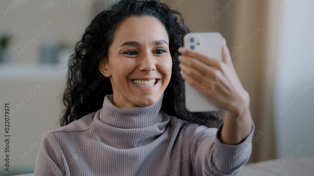 Excited young beautiful woman making video call using phone enjoy pleasant videoconference conversation curly girl smiling happily laughing wave hand talking on smartphone remote communication concept Excited young beautiful woman making video call using phone enjoy pleasant videoconference conversation curly girl smiling happily laughing wave hand talking on smartphone remote communication concept