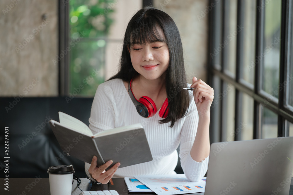 Young business woman is working and learning on paperworks and laptop in office space. Young business woman is working and learning on paperworks and laptop in office space.