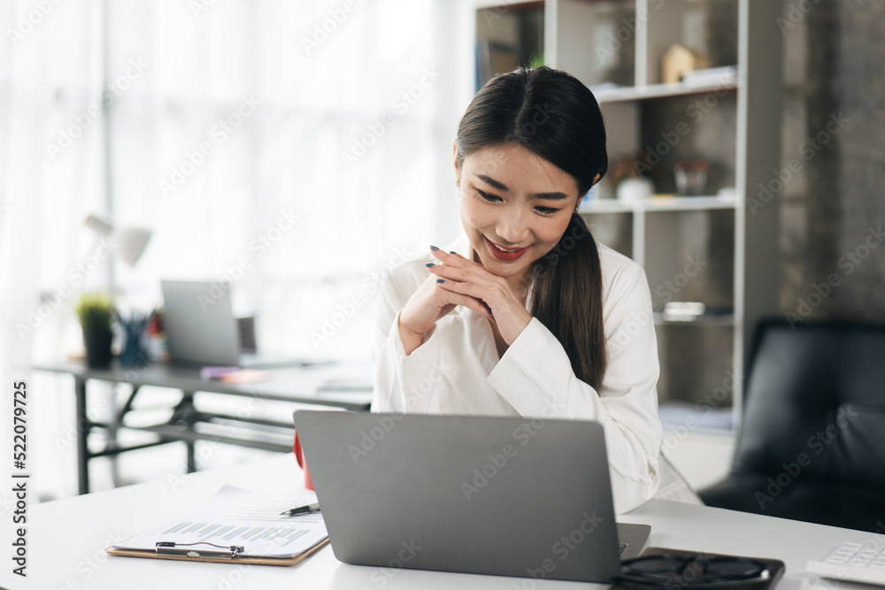 Young business women working on laptop with happy and smile face on office spec. Young business women working on laptop with happy and smile face on office spec.
