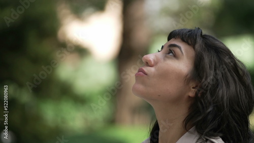 Happy woman looks up to Sky smiling. A contemplative hispanic girl having FAITH feeling JOY photo