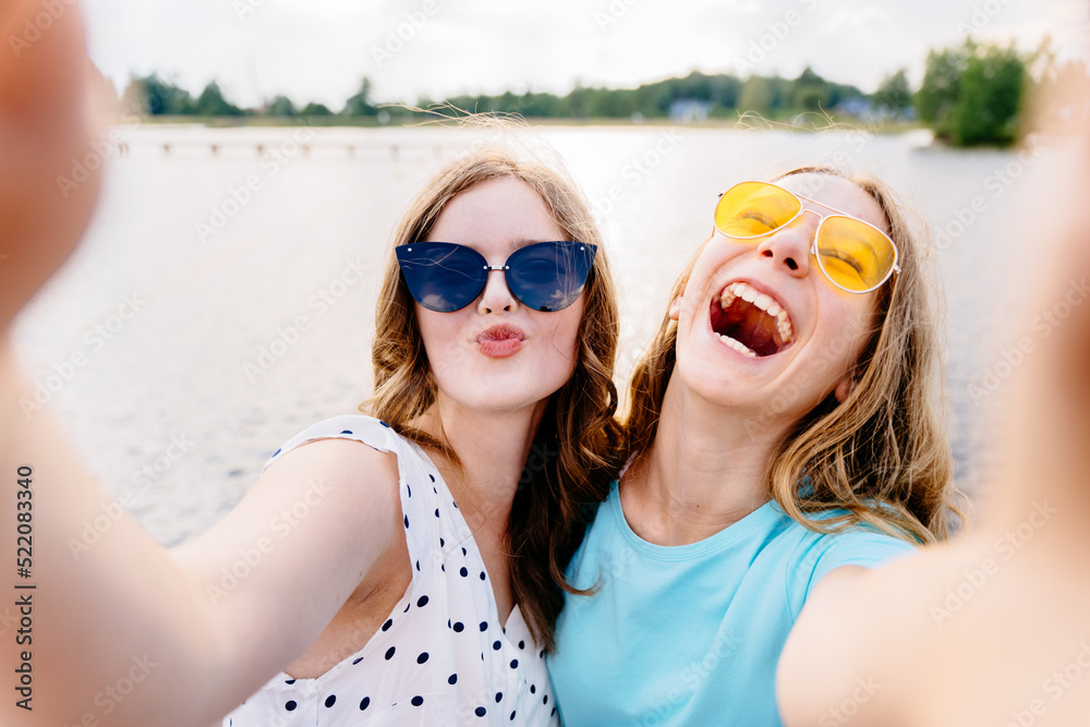 Two teenager girls friends in eyeglasses having fun, laughing,