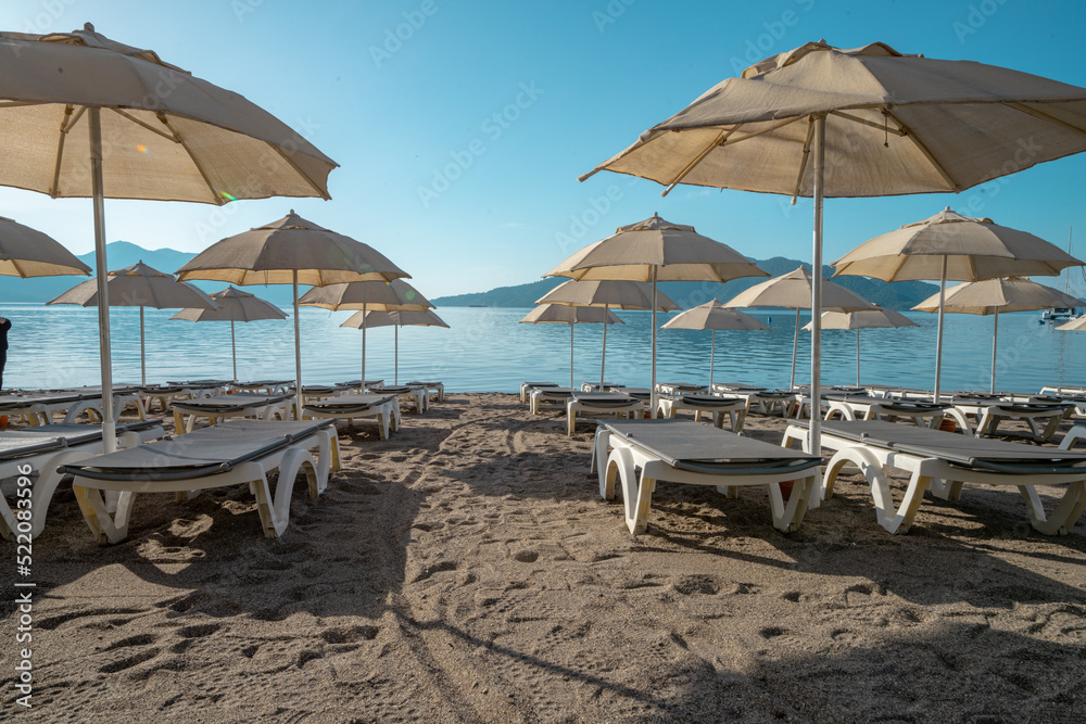 Summer sun beds near beach with umbrella. Beach resort