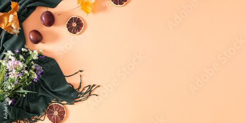 Autumn composition. Bouquet of wild flowers, dried orange slices, dry leaves, scarf on isolated beige background. Autumn, fall concept. Flat lay, top view, copy space