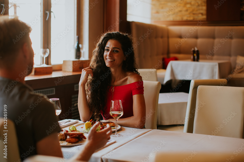 Young couple having lunch with white wine in the restaurant Young couple having lunch with white wine in the restaurant