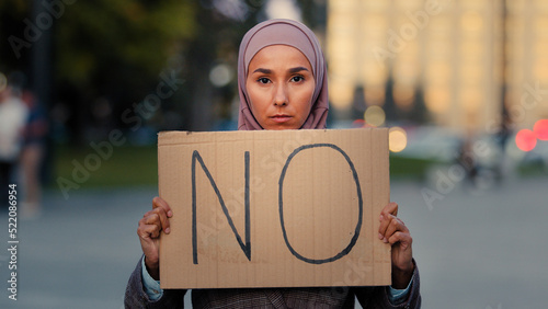 Canvas Print Stop racism No concept Arab immigrant Muslim woman in hijab protests against discrimination vax vaccination standing in city