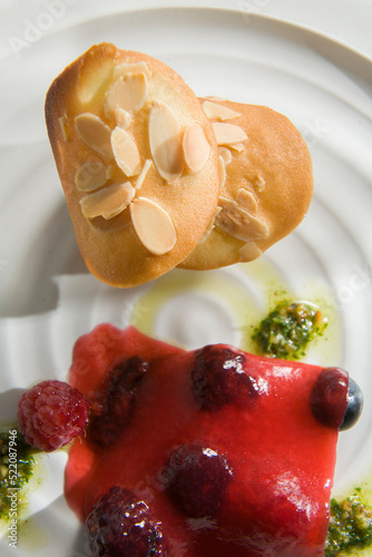 Goats cheese topped with nutty biscuit, raspberries with gelatinesed rasberry jus, and basil pesto.