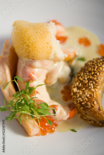 Prawn in creamy sauce, with red caviar, herbs and citrus dairy foam, and seed bread.