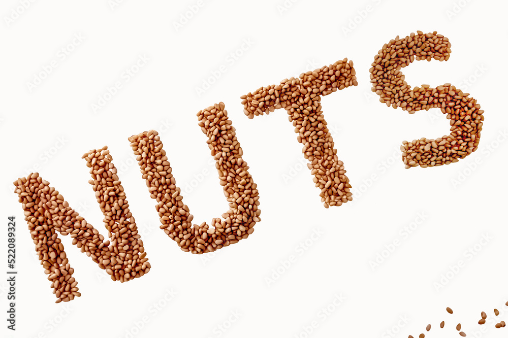The inscription _NUTS_ diagonally from pine nuts, white background The inscription _NUTS_ diagonally from pine nuts, white background