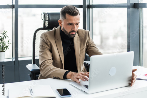 Fotografi Attractive businessman working on a laptop in the office