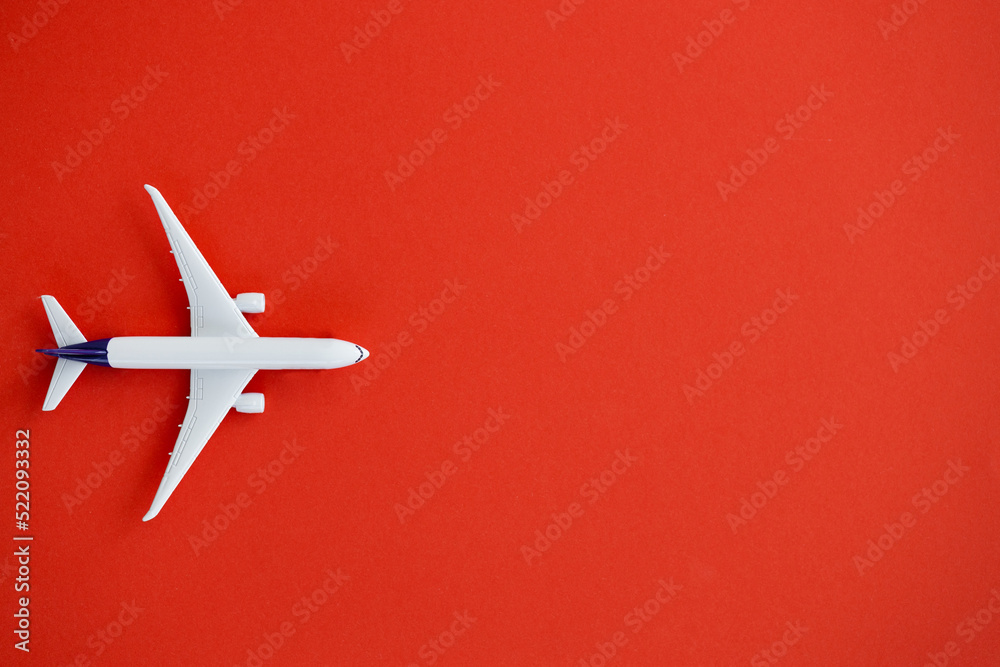 Flat lay design of travel concept with plane on red background