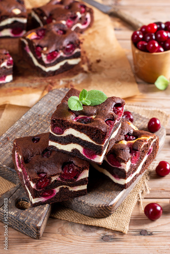 Homemade brownies with fresh berry on old wooden background