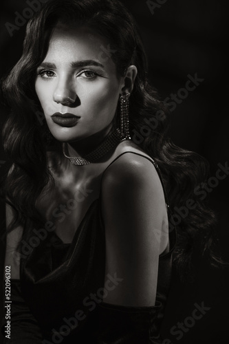 Portrait of woman in classic retro style of black and white Hollywood movies. Girl in vintage look with makeup and hairstyle with jewelry and gloves on hands