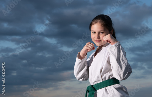 jujitsu girl in kimono on sky background photo