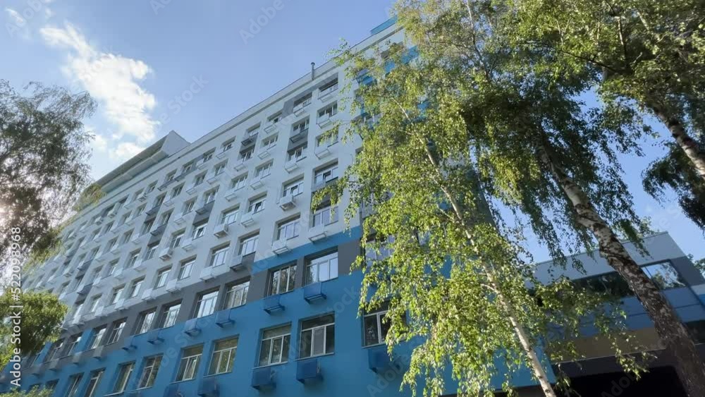 Hospital building exterior on a clear sunny summer day. Bottom up view of a clinic windows. Extreme wide angle view