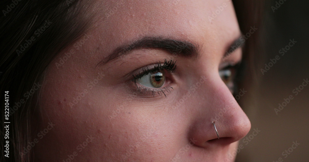 Young woman close-up of girl face with green eyes looking at horizon thinking about life in meditative contemplation Young woman close-up of girl face with green eyes looking at horizon thinking about life in meditative contemplation