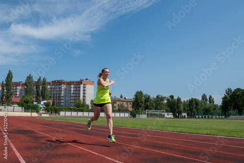 woman runs in the stadium.