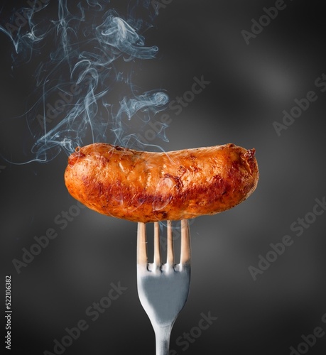 Tasty hot grilled sausages on a fork.