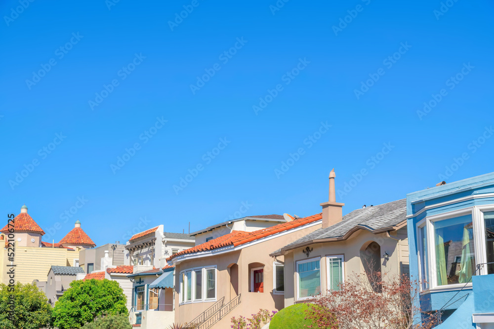 Row of houses with with clay roof tiles against the clear blue sky in San Francisco, California