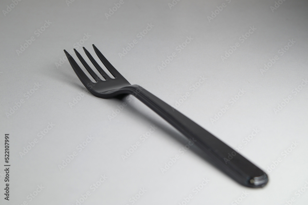 Fototapeta premium Black disposable plastic fork close-up. Disposable dishes. Soft focus