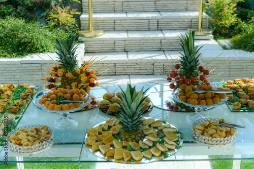 outdoors party finger food table, open-air buffet table, wedding aperitif catering. photo