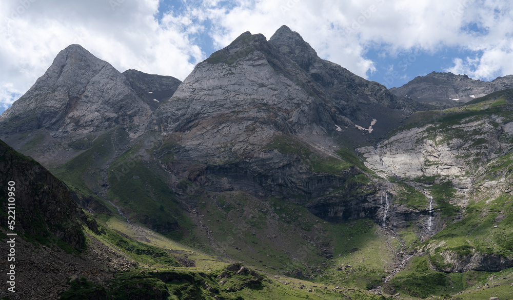 waterfalls on mountains slopes leading down to grass meadows