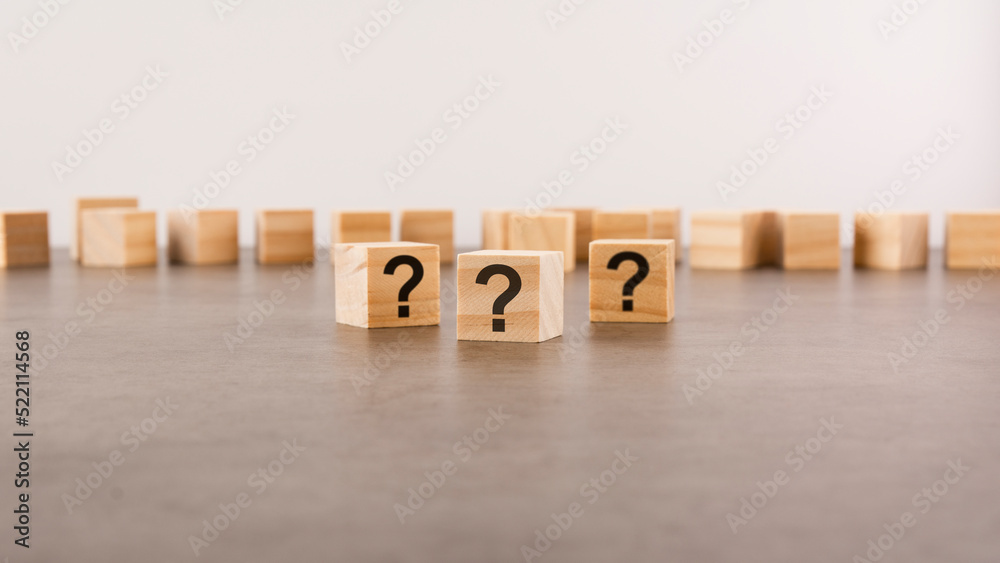 Obraz premium cube with question mark on wooden background. space for text