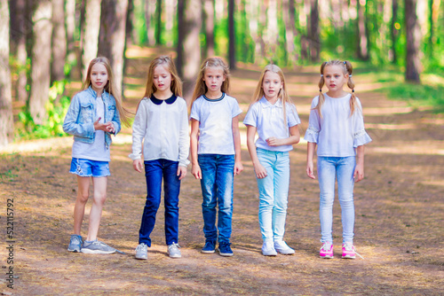 A group of five girls in the open air in the forest