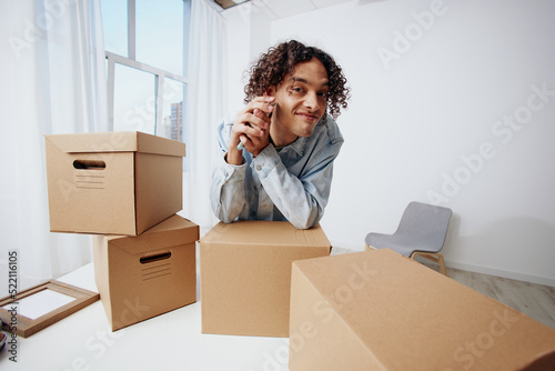portrait of a man with a phone in hand with boxes moving interior © SHOTPRIME STUDIO