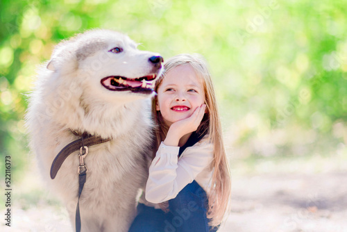 Happy little girl with a big dog outdoors in the park. Dog friend man © watman