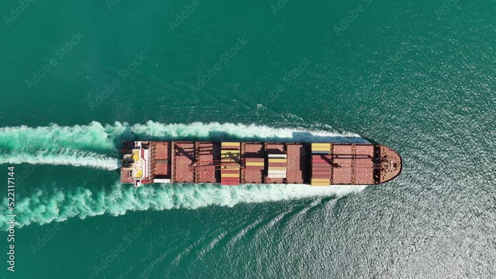 Aerial view Top speed with beautiful wave of container ship full load container with crane loading container for logistics import export or transportation concept background. 