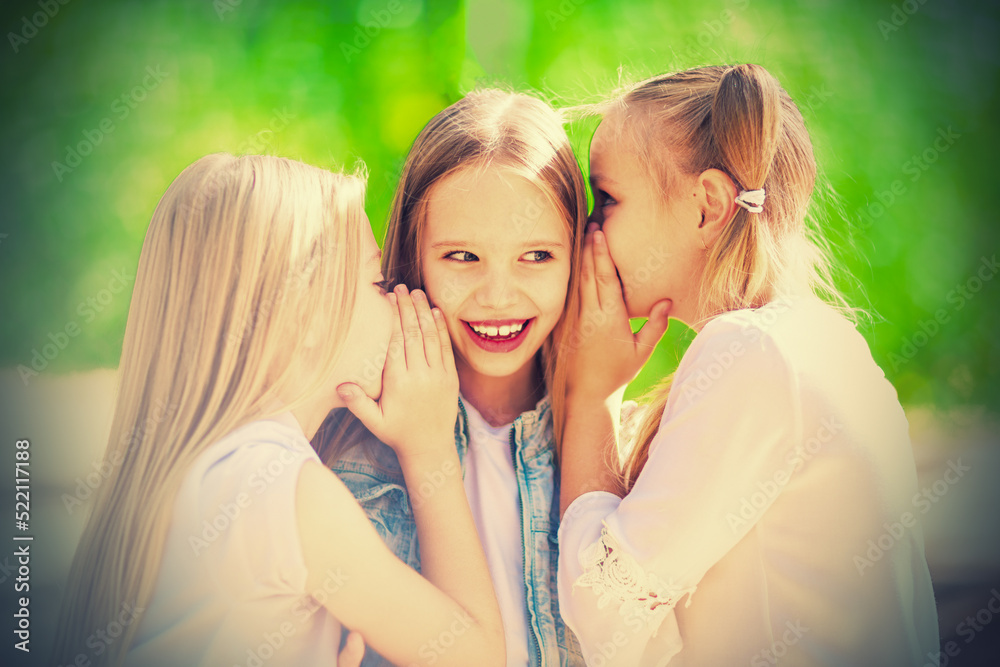 Three cheerful young girls are whispering for a walk in the park Three cheerful young girls are whispering for a walk in the park