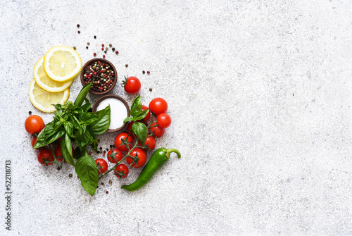 Pepper grinder, basil, cherry tomatoes on a white background with space for text. Food ingredients.